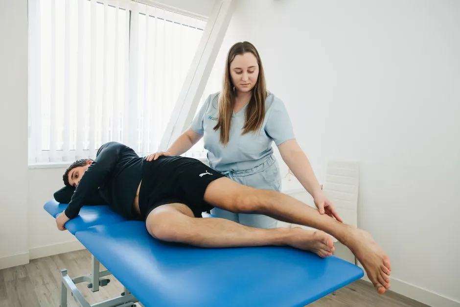 A therapist supporting a client through a movement session