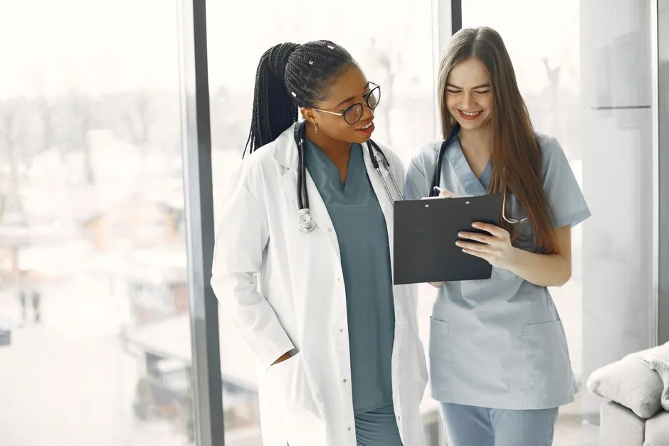 Two clinicians reviewing notes together in a bright room